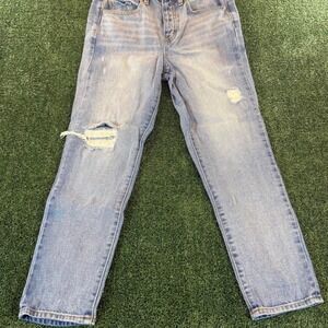 Light wash distressed denim jeans with button fly